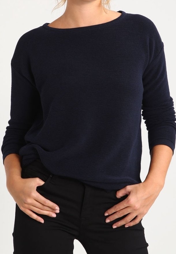 Top a maniche lunghe blu navy con vestibilità rilassata, caratterizzato da una texture a coste e ampia scollatura a barca, abbinato a pantaloni neri.