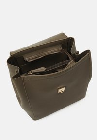 Kožená kabelka olivově zelené barvy s texturovaným povrchem, vybavená jedním zlatým kovovým zapínáním a několika vnitřními přihrádkami včetně zipů.