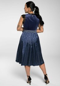 Marine jurk met een fluwelen top, kant cap sleeves en een geplooide rok met een bloemmotief. Inclusief een satijnen tailleband en zwarte hakken.