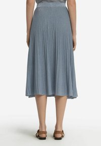 Fållad knälång kjol i ljusblått med en glänsande textur, med en åtsittande midja och en flödande nederkant.