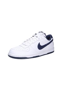 Baskets en cuir blanc avec des accents navy, boîtier de toe perforé, col rembourré et semelle en caoutchouc avec un motif de bande texturé.