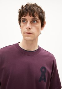 Bordeaux sweatshirt van katoenmix met een ronde hals. Bevat een getextureerd donkerblauw lintlogo op de linkerborst en subtiele schouderdetails.