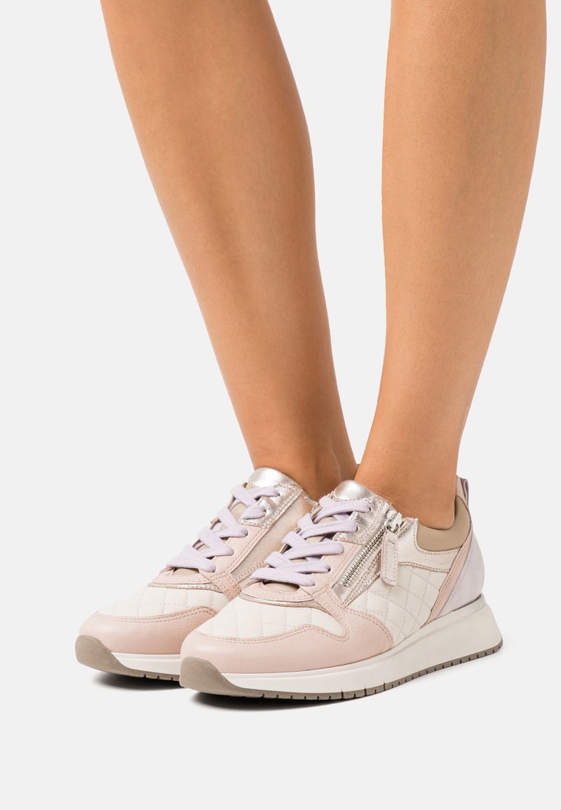 Light pink sneakers with a quilted pattern and metallic accents. Features a lace-up front, zipper on the side, and a cushioned sole.