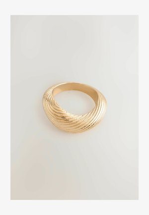 Gold ring with a twisted, ribbed design resting on a plain light background.
