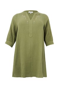 Olivengroene tuniek van gekreukeld materiaal met een V-hals, driekwartmouwen, decoratieve borduursels met kleine kraaltjes langs de halslijn.