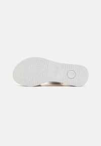 White rubber shoe sole with textured grip pattern, featuring brand name "Gabor" embossed and a circular accent near the heel.