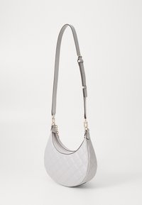 Quilted light grey shoulder bag with a curved shape, leather texture, adjustable strap, and gold-tone hardware accents.