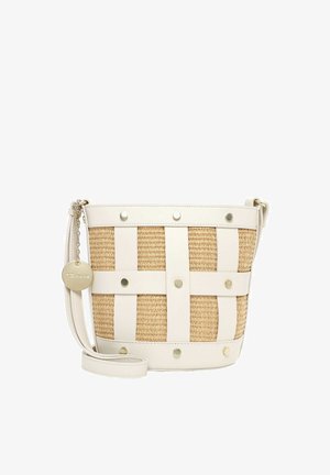 Bolso pequeño tipo cubo con cuerpo beige tejido, correas de cuero crema, tachuelas doradas, correa ajustable y un charm redondo dorado con la marca colgando del lado.