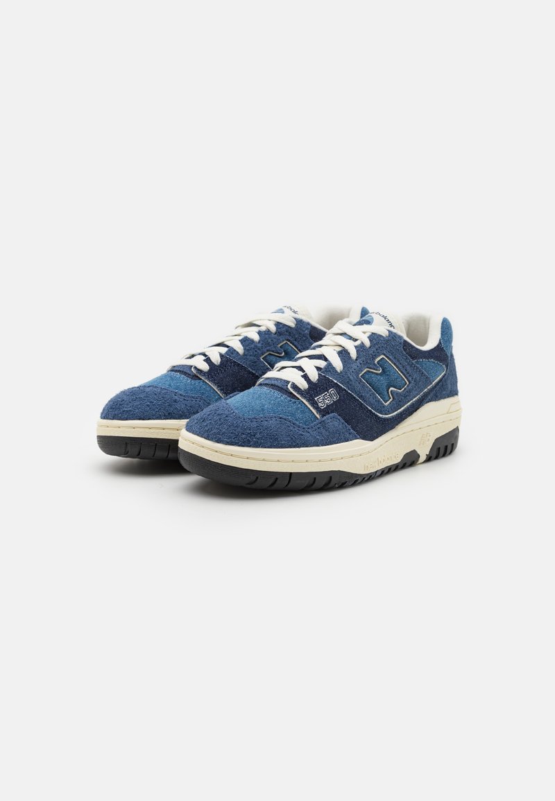 Baskets en daim bleu avec des lacets blancs, une semelle en caoutchouc crème et un dessus texturé comportant des accents bleu foncé et un logo sur le côté.