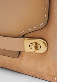 Borsa a tracolla in pelle color tan con una texture liscia, accessori in oro, chiusura a fibbia e dettagli in cucitura bianca.