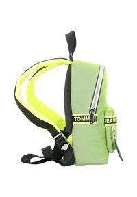 Zaino verde in nylon con accenti neri, dotato di una tasca frontale con zip, spallacci imbottiti e una fodera gialla brillante. Decorato con logo e accessori.