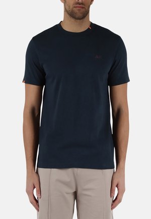 Maglietta a maniche corte blu navy in tessuto morbido, con scollatura rotonda e dettagli arancioni sulle spalle e sulle maniche.