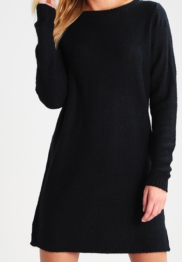 Svart stickad klänning med rund halsringning, lång ärm och avslappnad passform. Har ribbade manchetter och fåll. Mjuk struktur, minimalistiskt mönster.