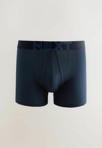 Temno modri bokserice z črnim pasom, ki ima modre napise "NEXT", narejene iz mehkega, elastičnega materiala z gladko teksturo.