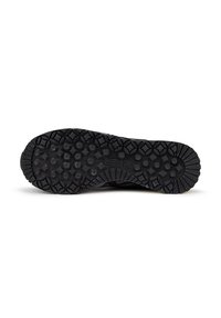 Suela de zapatilla deportiva negra con agarre texturizado, que presenta patrones circulares y de diamante para tracción. Logo "MUNICH" visible cerca del talón.