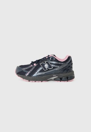 Scarpa sportiva nera con accenti rosa e suola grigia. Presenta una tomaia in rete con dettagli argentati e un prominente logo "N" sul lato.