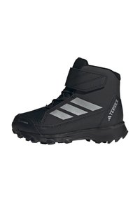 Black hiking boot with synthetic upper, reinforced toe, adjustable strap, and reflective accents, featuring a textured rubber sole for traction.