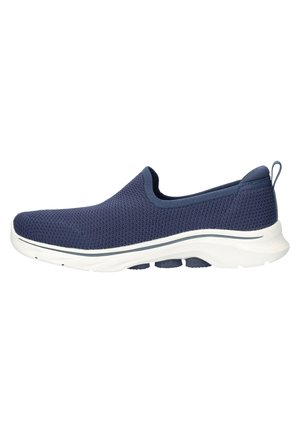 Zapato deslizante de malla en color marino con una suela blanca lisa, punta redondeada y un detalle mínimo. Cuenta con una pestaña en el talón para facilitar su uso.