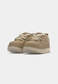 Beige plattformsneakers med semsket og mesh-paneler, rund tå og snøredesign. Teksturert gummisåle med riller for grep.
