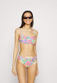 Conjunto de biquíni floral com um padrão multicolorido de flores rosa, azuis e amarelas. O top é de estilo cropped e a parte de baixo tem um corte de altura média.