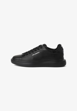 Zapatilla deportiva de cuero negra de corte bajo con suela gruesa, cordones negros y logo "KARL LAGERFELD" en el lateral.
