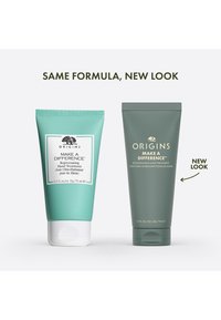 Kaksi käsivoideputkea rinnakkain: vasemmalla petroolinvihreä valkoisilla yksityiskohdilla; oikealla tummanvihreä kultaisella tekstillä; molemmat merkinnällä "Make a Difference."