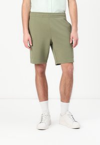 Grønne shorts i bomullsblanding med avslappet passform, elastisk midje og sidelommer. Avsluttet med ribbestrikket detalj i kanten.