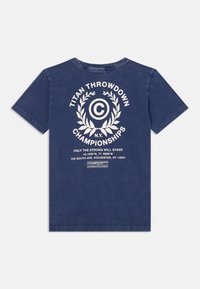 Námorně modré bavlněné tričko s bílým grafickým designem na zádech, včetně textu a motivu vavřínového věnce. Krátké rukávy, kulatý výstřih.