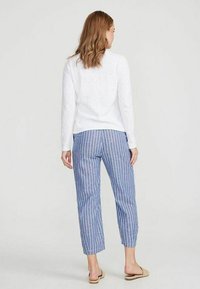 Witte langemouwen top, blauw-witte gestreepte cropped broeken. Casual pasvorm, lichte stof, met een eenvoudige textuur en een elastische tailleband.