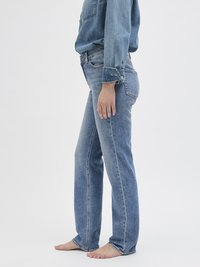 Gaišzilas denim bikses ar taisnu kāju dizainu, vidēju jostas augstumu un nelielu izbalējumu. Iezīmē klasiskās šuves un sānu kabatas.