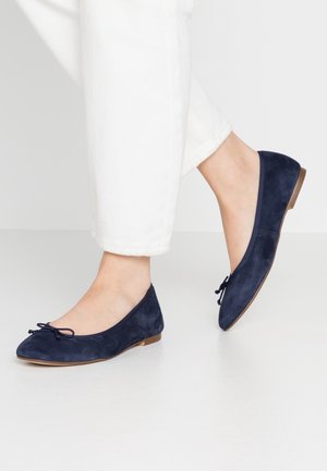 Granatowe zamszowe baleriny z zaokrąglonym nosem i ozdobnym detalem w postaci kokardy. Płaska podeszwa z minimalną wysokością obcasa, gładka tekstura.