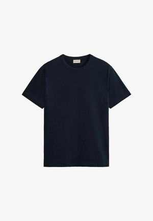 Camiseta sencilla de algodón azul marino de manga corta con cuello redondo, doblada cuidadosamente sobre fondo blanco.