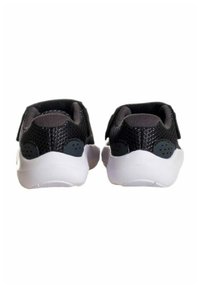 Sneaker in mesh nero con suola bianca, caratterizzati da una parte superiore testurizzata, cinturini regolabili e piccole perforazioni per la traspirabilità.