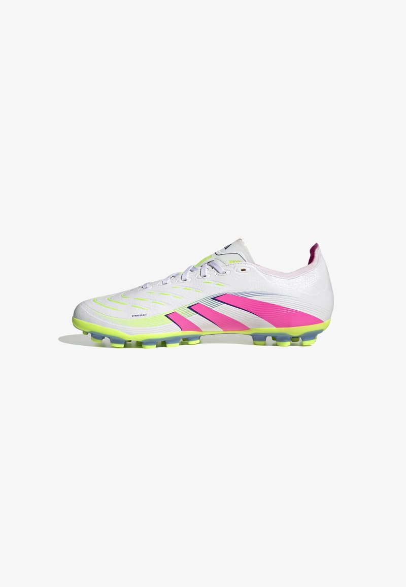 Scarpette da calcio bianche con dettagli in rosa e verde neon, tomaia texturizzata e tacchetti sagomati per una migliore aderenza. Design elegante e moderno.