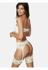 Witte kant lingerie set bestaande uit een strapless top, een kousenband en hoge kousen met bloemmotieven en verstelbare straps.