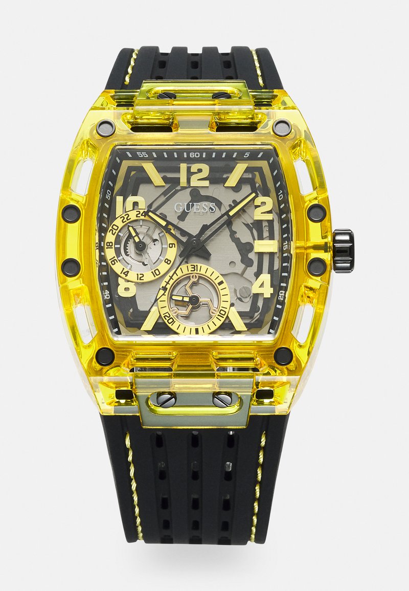 Yellow transparent watch with black rubber strap, large round face, prominent numerals, black and yellow accents, and intricate mechanical details.