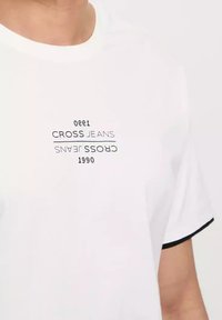 Biała koszulka z krótkim rękawem z kontrastowym czarnym wykończeniem, z odwróconym napisem "CROSS JEANS 1990" oraz "1300".