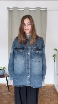 Denim overshirt in faded blue features two chest pockets, button-up front, and a casual fit. Worn over a gray turtleneck.