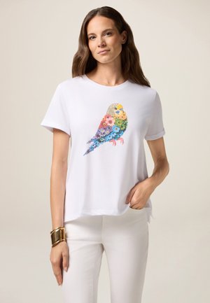 Witte t-shirt met een kleurrijk vogelontwerp gemaakt van bloemenpatronen. Het shirt heeft korte mouwen en een relaxte pasvorm.