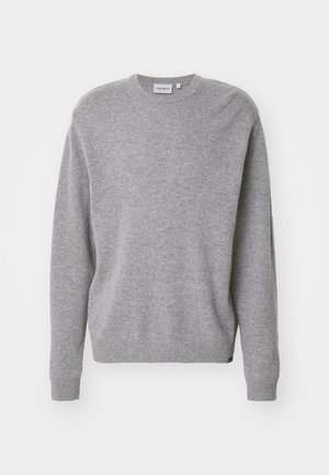 Pull en tricot gris avec des manches longues, un col rond et des bords-côtes aux poignets et à l'ourlet. Le tissu semble doux et texturé, conçu pour un usage décontracté.