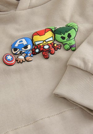 Beige Sweatshirt mit drei bunten Charakter-Patches: Captain America, Iron Man und Hulk. Schmuseweicher Stoff, gerippte Bündchen.