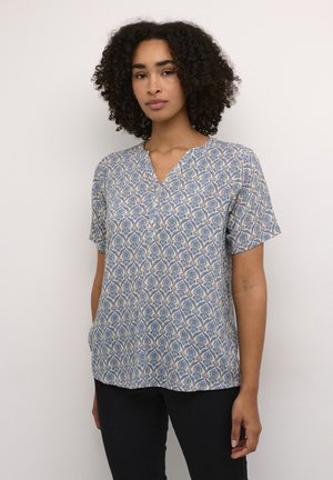 Blouse à manches courtes bleu et crème à motif, avec un décolleté en V et une coupe décontractée. Le tissu a une texture lisse et des détails subtils de motif floral.
