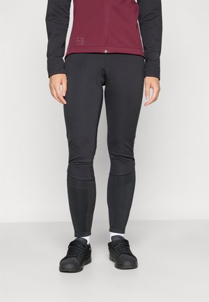 Sorte stretch leggings med en tett passform. Kombinert med en burgunder zip-up jakke med svarte ermer og en reflekslogo-detalj.