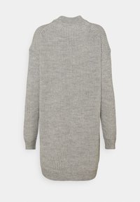 Maglione grigio lavorato a maglia con una texture a coste, maniche lunghe e collo alto. La parte posteriore è leggermente più lunga della parte anteriore.