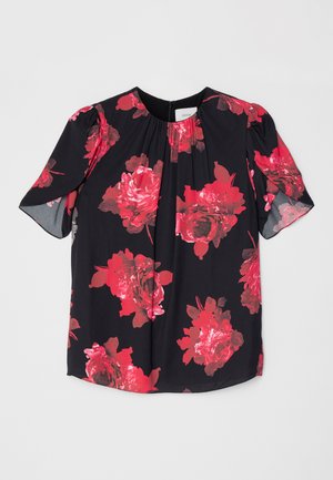 Schwarze Bluse mit floralen Motiven, die große rote Rosen zeigt, kurze Ärmel und ein dezentes Falten-Detail am Ausschnitt hat. Hergestellt aus einem leichten Stoff.