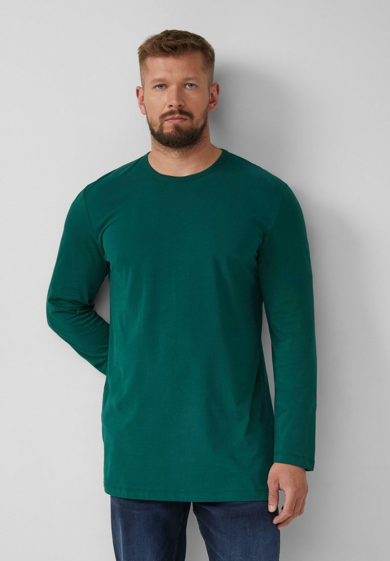Lange mouwen groen shirt in een soepele katoenmix, met een ronde halslijn en een rechte snit, gecombineerd met donkere jeans.