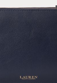 Ναυτικό δερμάτινο clutch με λεία υφή, που διαθέτει φερμουάρ σε χρυσό τόνο και ανάγλυφο λογότυπο "LAUREN RALPH LAUREN" στο μπροστινό μέρος.