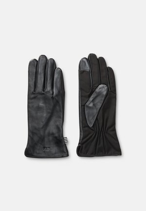 Ein Paar schwarze Lederhandschuhe, einer zeigt die Handfläche mit einem Lederpatch am Daumen und elastischem Handgelenk, der andere zeigt die glatte Rückseite mit MN-Prägung.