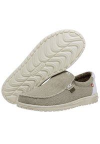 Bottes beiges à enfiler avec un dessus en tissu texturé, des accents élastiques sur les côtés et un capuchon de talon blanc. Présente une semelle en caoutchouc flexible avec un motif de semelle.