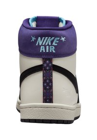 Baskets montantes avec col en daim violet, corps crème, accents noirs et sangle décorative à motif. Présente une broderie "NIKE AIR".